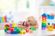 © famveldman - Kids toys. Child building tower of toy blocks.