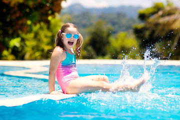 Child in swimming pool. Summer vacation with kids.