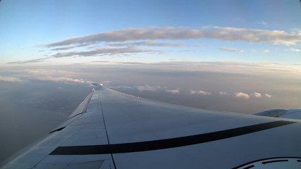 Wall Mural - 4K, Timelapse aerial view of beach in Taiwan island. See the wing of a plane as seen through airplane window. Passenger POV traveling by air. Aircraft during the flight with grey sky and clouds. -Dan