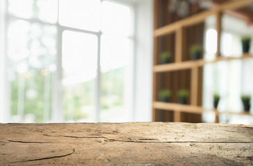 Wood table top on blur of window glass and abstract green from garden with city view in the morning background. For montage product display