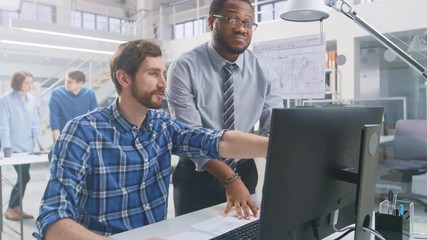 Aufkleber - In the Industrial Engineering Facility: Portrait of the Handsome Male Engineer Working on Desktop Computer, Chief Engineer Stands Beside and Explains Particularities of the Task and Project Details. 