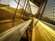 Angled Photo of a Baseball Dugout at Sunset - with Bleacher Seats, Chainlink Fences and Streaming Sprinklers in the Background