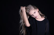 © Alla - Portrait of a blonde girl with long hair on a black background. Emotional portrait.The girl shows different emotions on the face. Plays with long hair.