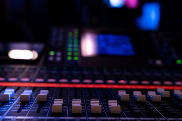 Close up of faders on an audio mixing console in a concert venue