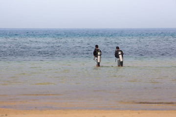 two diver walking in the sea with dive equipment a relaxing water sports scene 