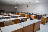 Fototapeta  - Education concept: Empty college or university classroom with wooden tables and chairs in row without student or teacher in the room. School classroom with window opened, clean and tidy ready for new 