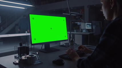 Poster - Over the Shoulder Shot of Engineer Working with Green Mock-up Screen Desktop Computer. In the Background Engineering Facility at Night Blueprints and Drawings with Showing Industrial Design