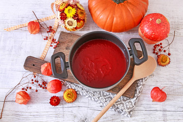 Wall Mural - Creamy autumn soup in white plate. Seasonal pumpkin decorations