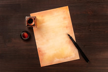 A Vintage Background With A Nib Pen On A Piece Of Old Paper, With An Ink Well, Shot From Above On A Dark Wooden Background With A Place For Text