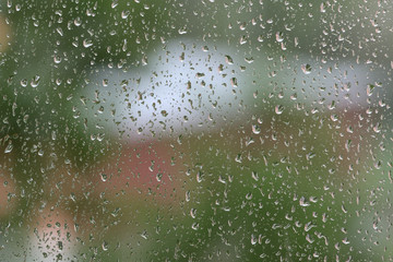 Raindrops on window glass during the rain close up. Natural background