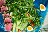 Fototapeta Lawenda - Tuna with salad and vegetables on blue plate