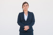 © Mangostar - Serious confident manager posing for corporate portrait. Young woman in office suit standing with clasped hands and looking at camera. Business portrait concept