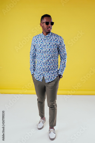 Fotografía Portrait of attractive young african man sunglasses on yellow wall