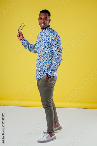 Fotografía Portrait of attractive young african man sunglasses on yellow wall