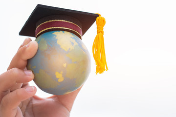 Education world or Graduated study abroad international ideas. Graduation hat on top Earth globe model map background. Congratulations to graduates university lead to success in world. Back to School