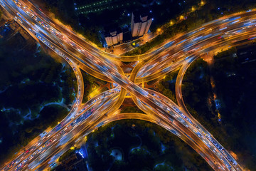 Wall Mural - Aerial view of highway junctions shape letter x cross at night. Bridges, roads, or streets in connection or transportation concept. Structure of architecture in urban city, Shanghai Downtown, China.