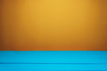 Fototapete - Beautiful blue wooden table and orange wall background.