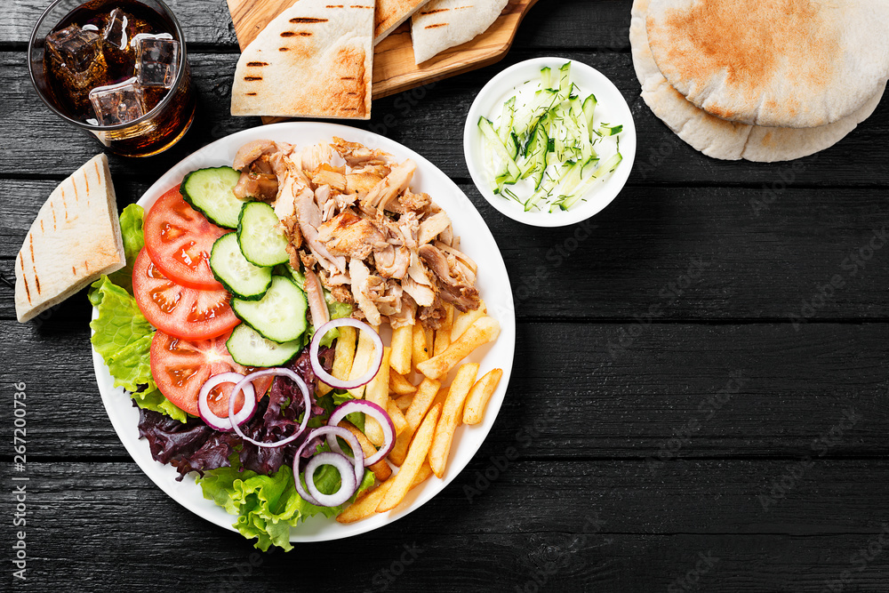 Doner kebab or gyros on a plate with french fries, pita bread and salad.,  obrazy, fototapety, plakaty - BajeczneObrazy.pl
