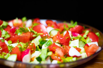 Close-up, delicious fresh vegetable salad cucumber tomatoes radishes cheese greens, vegetarian cuisine, healthy food, diet