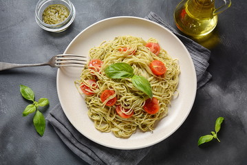 Pasta spaghetti with pesto sauce, fresh basil and cherry tomatoes . Italian traditional food