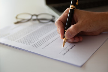 Businessman signing paper, male hand signature on business document