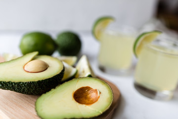 Wall Mural - Fresh avocado, lime, drink and nacho chips lying on marble background. Recipe for Cinco de Mayo party