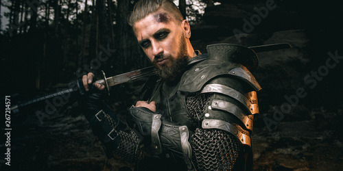 Fotomural mystery scarface knight in armor with sword and crossbow in the forest
