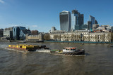 Fototapeta Londyn - Tugboat with container boats in tow on the river Thames.