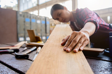 Wall Mural - Carpenter working with equipment on wooden table in carpentry shop. woman works in a carpentry shop.