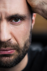 Wall Mural - partial view of crying man with tears on face looking at camera