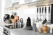 Different Appliances, Clean Dishes And Utensils On Kitchen Counter