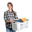 Happy young woman holding basket with laundry on white background