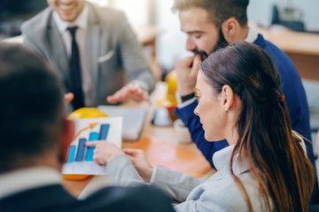 Businesswoman pointing at chart while sitting at meeting in boardroom. Difficult things take a long time, impossible things a little longer.