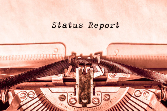 rstatus report printed on a sheet of paper on a vintage typewriter. business. financial statement.