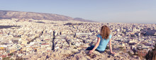 Young Woman Looks At Cityscape Of Athens, Greece. Adult Girl Tourist Relaxes On Hill Top Overlooking Athens In Summer. Panoramic View Of The Famous Athens City From Above. Travel And Vacation Concept.