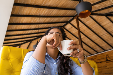 girl hold cup of coffee in hand look in window in coffee shop