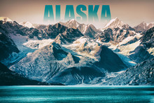 Alaska Glacier Bay Landscape National Park, USA. Alaska Text Written As Title Above Mountain Top For Cruise Destination. Background Of Snow Capped Mountains Peaks At Sunset Winter Vacation.