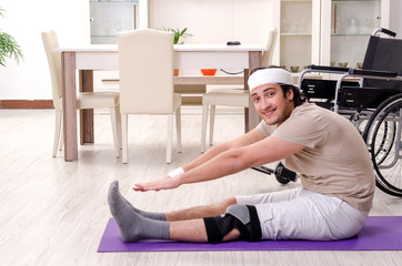 Injured young man doing exercises at home 