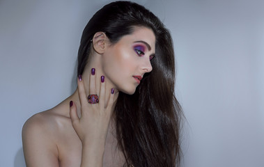 Wall Mural - Beauty fashion model girl with nailart and purple make up, hair and jewellery on light background. Nail designs with decoration