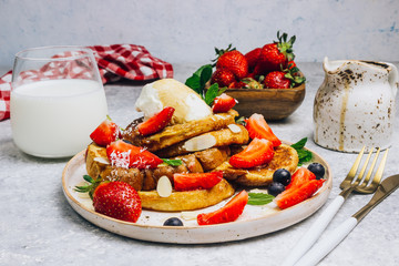 Wall Mural - Stecked french toast topped with strawberries, blueberries, mint, ice cream and maple syrup