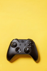 Black joystick gamepad, game console on yellow colourful trendy modern fashion pin-up background. Computer gaming competition videogame control confrontation concept. Cyberspace symbol