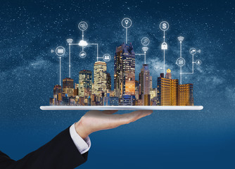 Wall Mural - Smart city, building technology, and real estate business. Businessman holding digital tablet with buildings hologram and application programming interface technology