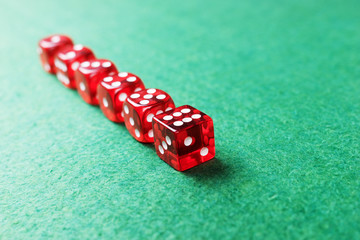 A row of red dices from one to six on green background