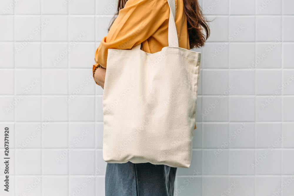 Woman is holding bag canvas fabric for mockup blank template. - obrazy, fototapety, plakaty 
