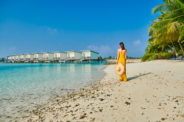 Wall Mural - Woman in dress walking on tropical beach