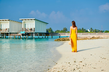 Wall Mural - Woman in dress walking on tropical beach