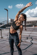 © byswat - Woman athlete involved in fitness fitness workout, in summer in the city, day and morning. Active lifestyle, the concept of warming up before jogging. Sportswear leggings top. Tanned skin in tattoos.