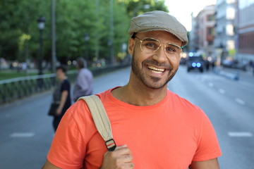 Retro styled ethnic man smiling outdoors