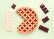 jam cake and chocolate pieces in colored background, viewed from above