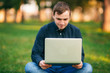 © Aleksandr - Programmer working in the park on laptop. Man sitting on bench